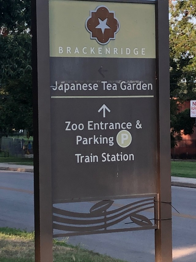 Large brown sign pointing to destination.