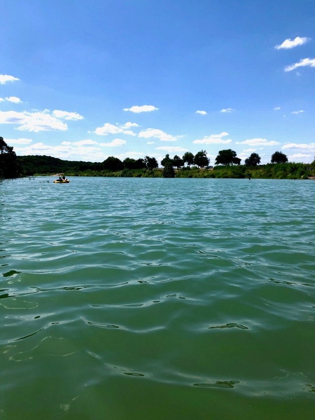 Emerald green river under a bright blue sky.